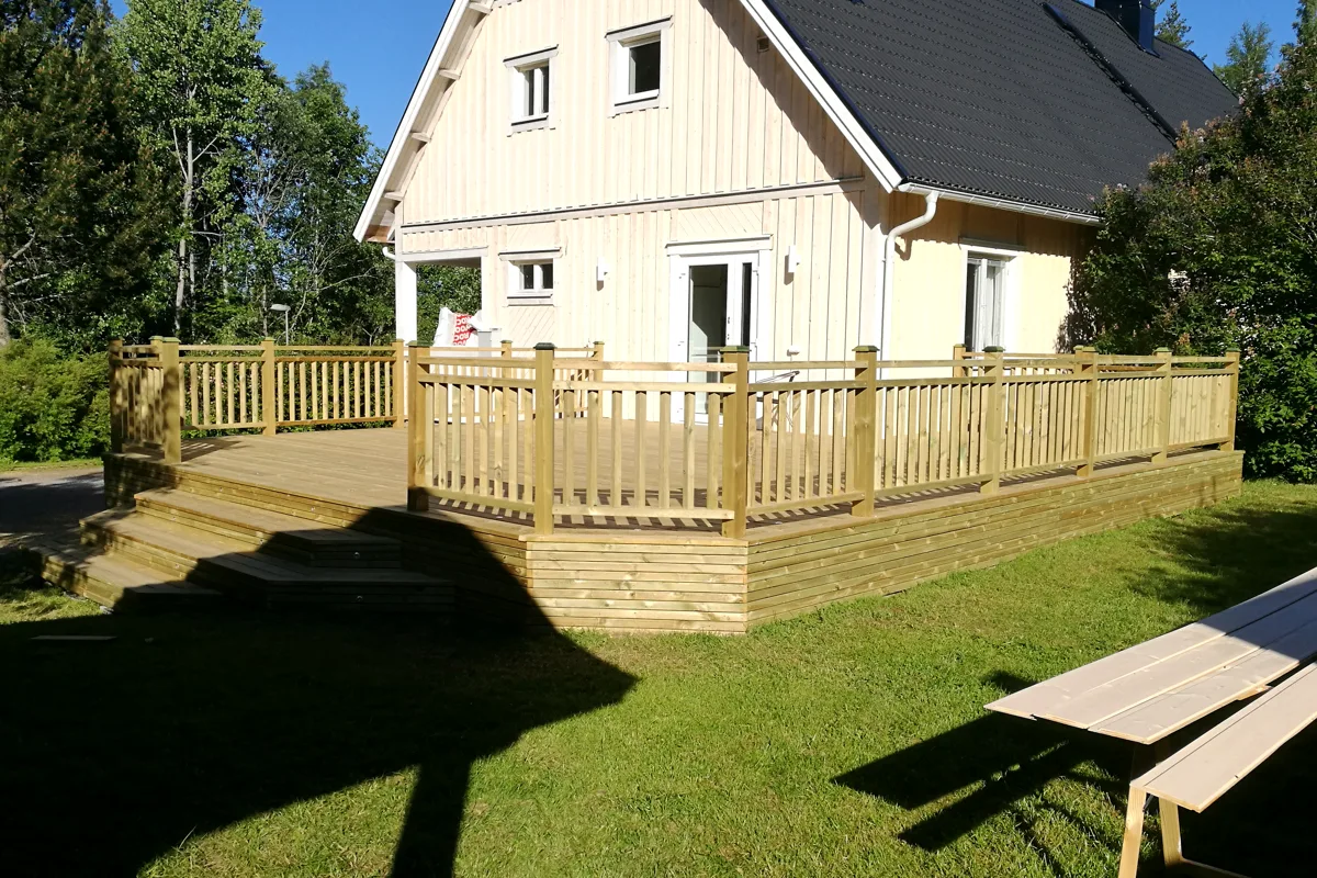 Ljust trähus med ny altan och räcke