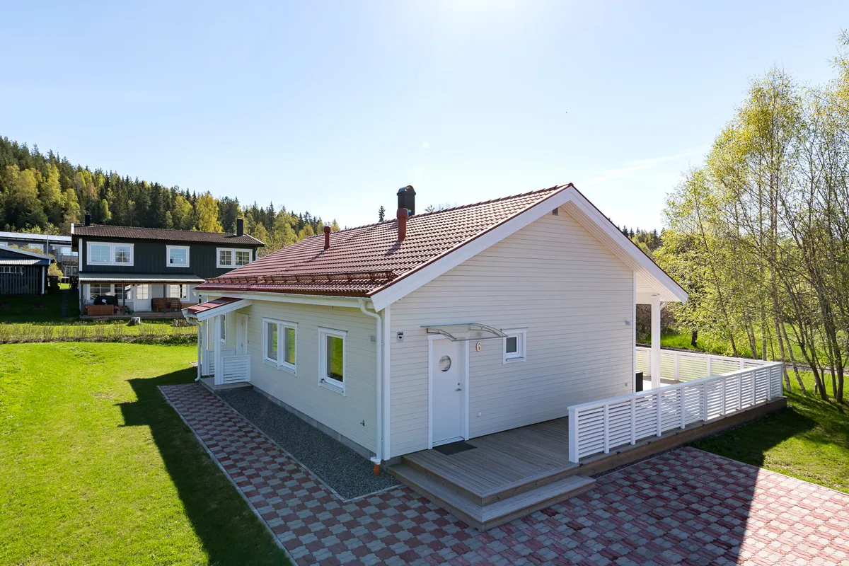 Vit villa med rött tak och plattsatt gång