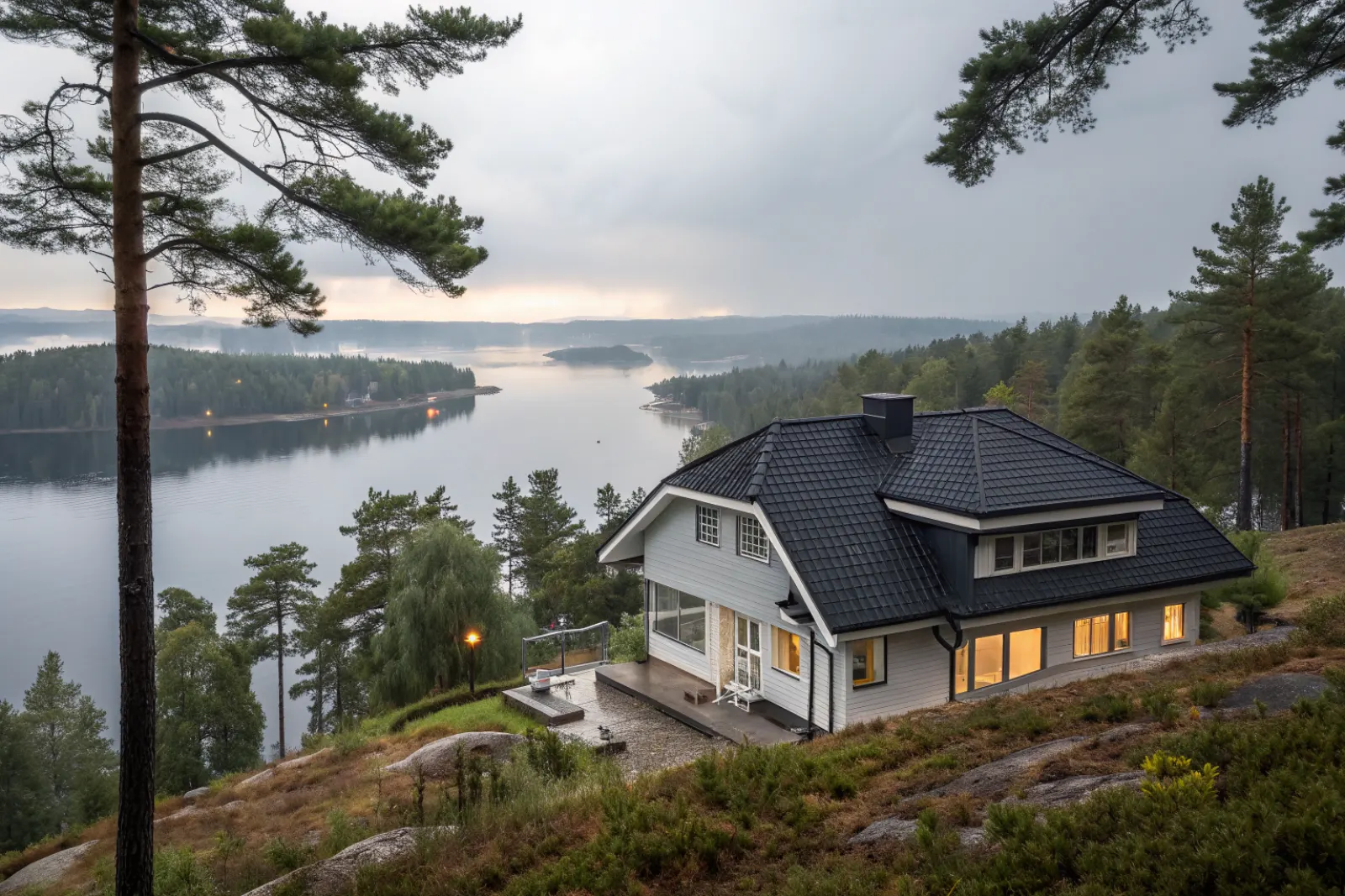 Villa från 1960-talet med betongpannor i sluttning ovanför en sjö i Tullinge
