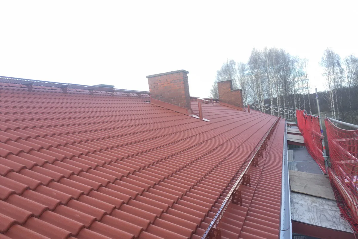 Nock och plåtdetaljer längs ett långt rött tak