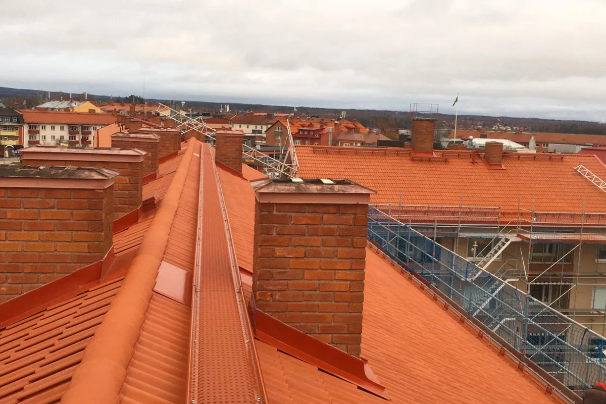 Nylagt orange tak med flera skorstenar på ett flerbostadshus