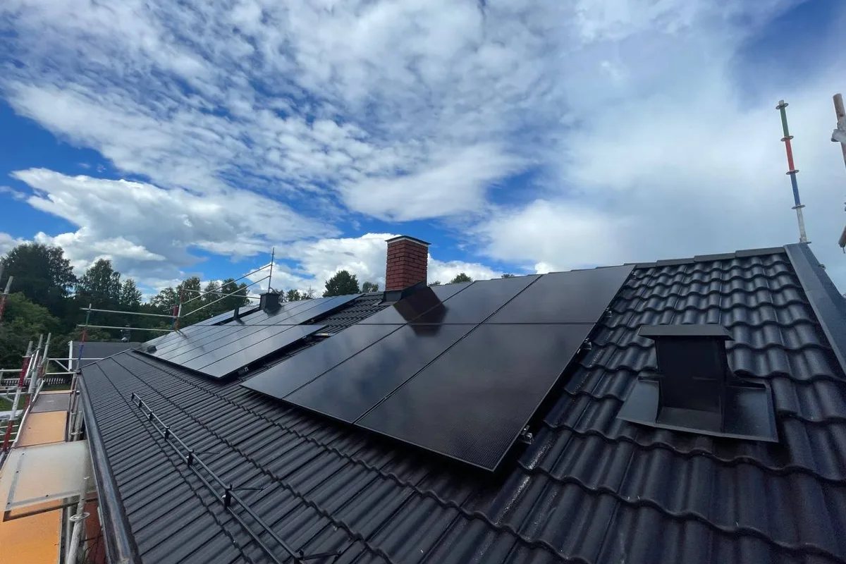 Svart pannat tak med solpaneler och takfönster