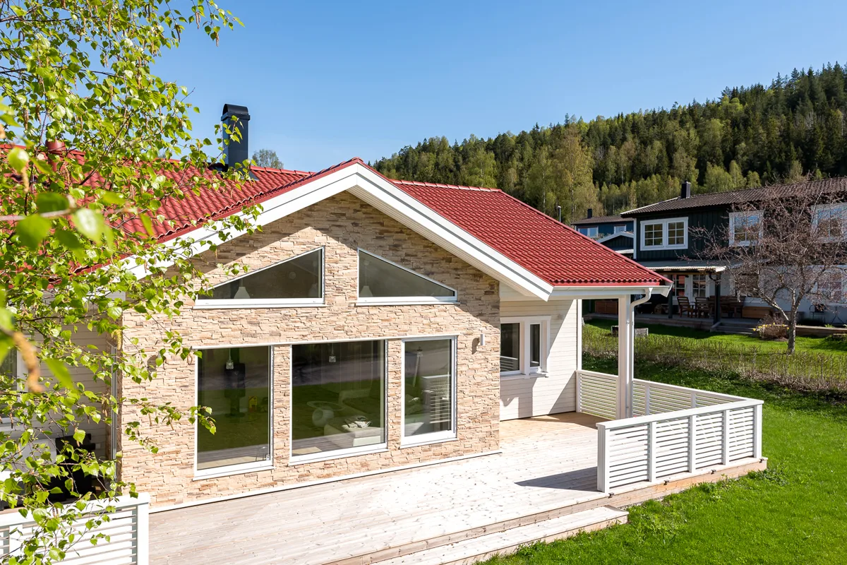 Villa med en del i sten och stora glaspartier
